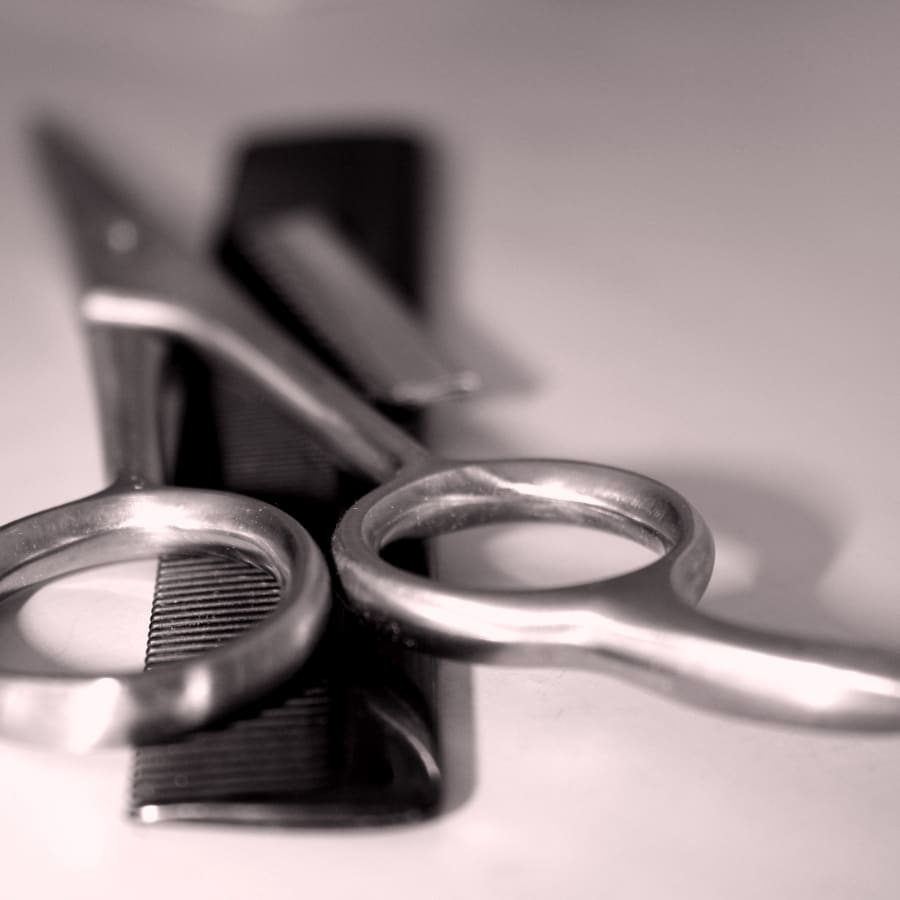 Tijeras y peine de barbería sobre fondo claro