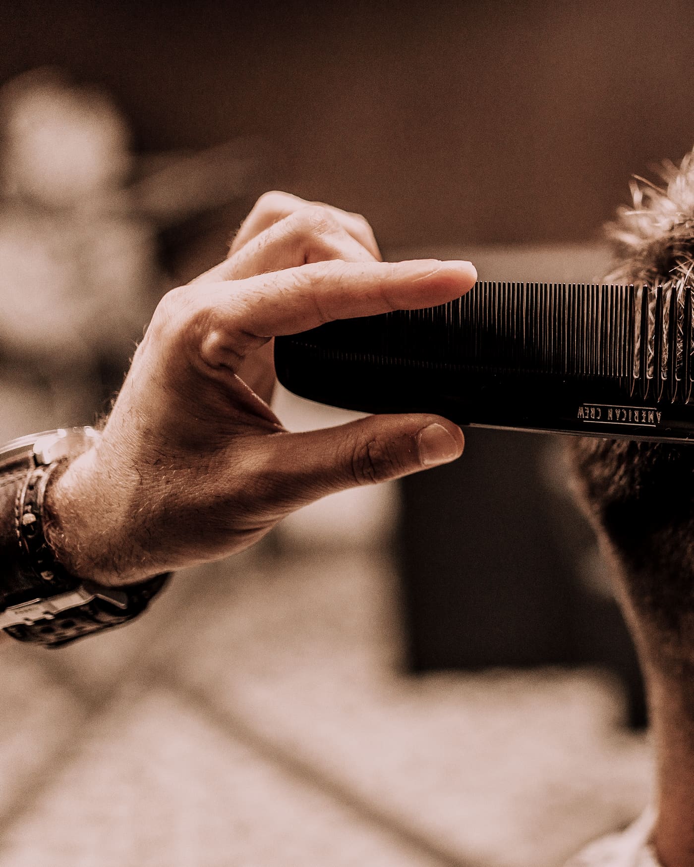 Barbero perfilando un corte con máquina y peine
